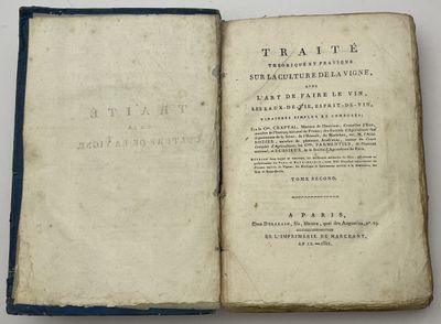 un livre ouvert posé sur une table à côté d'une table blanche