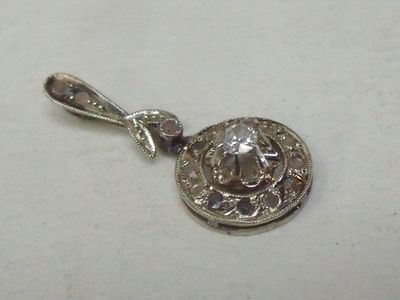 une photo d'un pendentif en argent orné d'un diamant