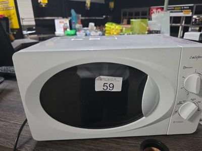 un micro-ondes blanc posé sur une table, avec une étiquette de prix dessus