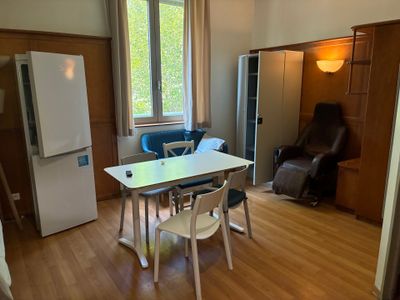 une table et des chaises dans une pièce équipée d'un réfrigérateur