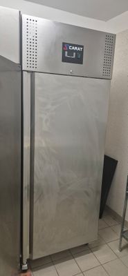 a stainless steel refrigerator in the corner of a room