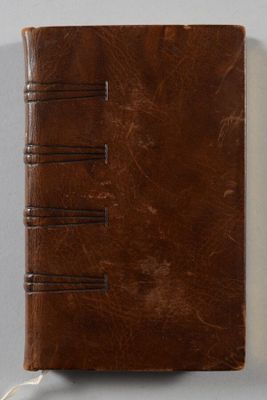 un carnet en cuir marron sur lequel est posé un marque-page