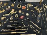 a lot of gold jewelry on a black table