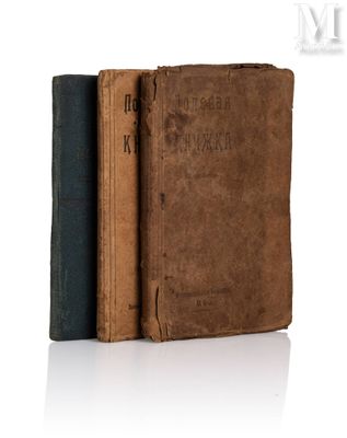 trois vieux livres sont empilés sur une surface blanche