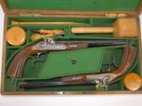two guns in a green case on a white table
