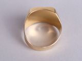 a gold ring that is sitting on a white surface