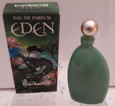 un flacon de parfum posé sur une table à côté d'une boîte de parfum