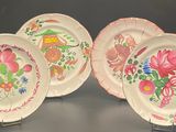 three plates with floral designs on them on a table