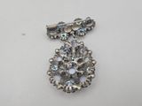 a close up of a silver broochle on a white surface