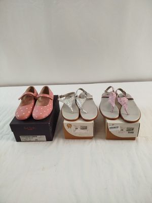 trois paires de chaussures roses et blanches posées sur une surface blanche