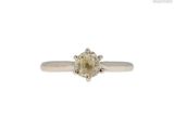 a close up of a yellow diamond ring on a white background