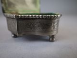 a silver box with a green lid sitting on a table