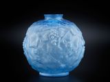 un vase en verre bleu posé sur une surface noire