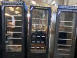 several glass door refrigerators are lined up in a warehouse