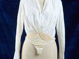 une image représentant une chemise blanche sur un mannequin, sur fond bleu