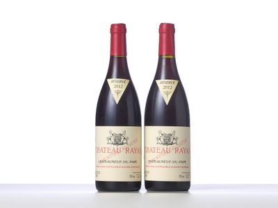 two bottles of red wine sitting on top of a table