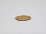 a small gold coin sitting on top of a white surface