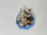 un bol bleu rempli de pièces d'argent et d'or