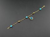 un bracelet en or orné de perles de verre turquoise et d'une chaîne en or