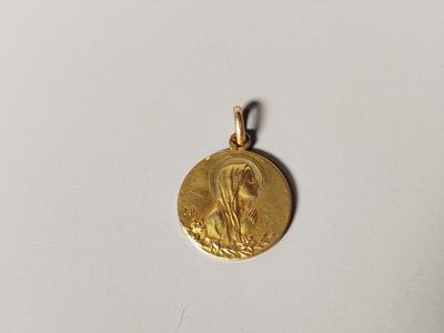 a gold coin with a virgin on it sitting on a white surface