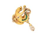 an image of a gold broochle with a green and white pearl