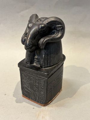 statue représentant une tête de bélier posée sur une boîte portant une inscription égyptienne