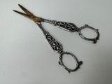 two pairs of scissors sitting on a white surface