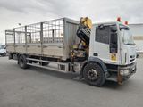 un camion blanc équipé d'une cage à l'arrière, garé sur un parking
