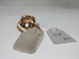 une image d'une bague en or sur une surface blanche avec une étiquette de prix