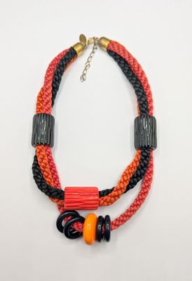 a close up of a necklace on a white surface
