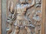 carved wood panel of a man holding a sword and a dog