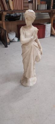 une statue représentant une femme assise sur une chaise dans une pièce