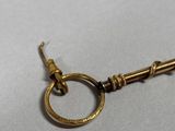 a close up of a gold keychain with a ring on it