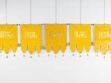 a row of yellow pennants hanging on a wall in a room