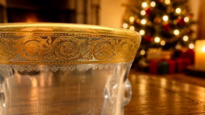 un verre posé sur une table, avec un sapin de Noël en arrière-plan