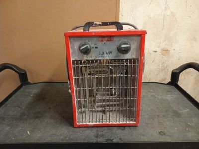 a small red heater sitting on top of a table