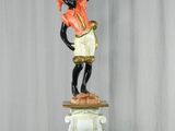 a statue of a man holding a candelier on top of a pedestal