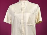 a white shirt on a mannequin stand against a purple background