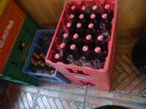 a red crate full of soda bottles sitting on the floor