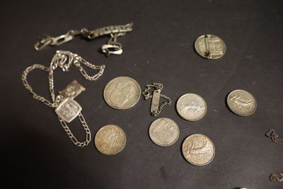 beaucoup de pièces de monnaie et un collier posés sur une table