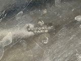 a close up of a silver plate with a black background