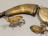 two figurines of animals and a horn on a table