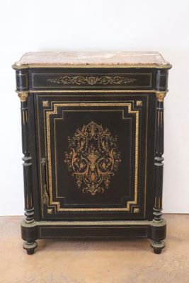 une photo d'un meuble peint en noir et or, avec un plateau en marbre