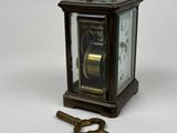 a small clock with a key attached to it
