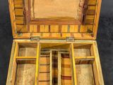 une petite boîte en bois compartimentée posée sur une surface noire