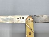 a knife that has a gold handle on it