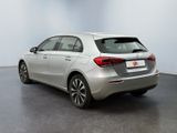 the rear end of a silver car in a white room