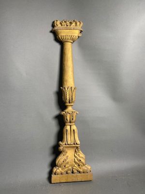 a gold candle holder on a grey background with a gray background