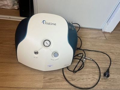 a white and blue machine sitting on the floor next to a wall