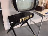 un petit téléviseur posé sur un meuble dans une pièce